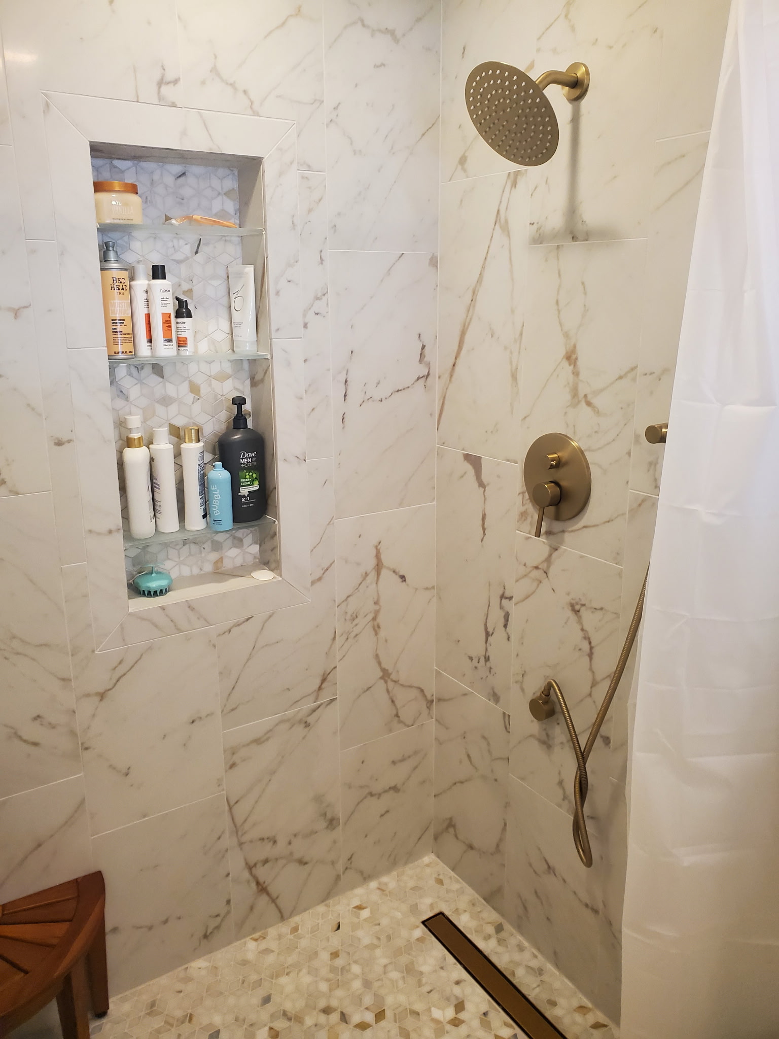 Master shower remodel with marble tile and gold fixtures